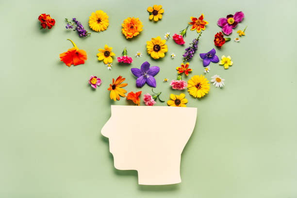 istock Human head symbol and flowers on blue background 1457208021