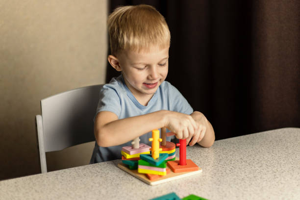 A boy is playing an educational puzzle toy. Happy child stock photo