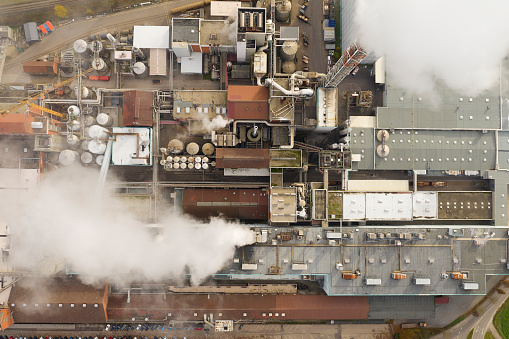Air pollution from smoke stacks at a paper mill, bird's eye view.