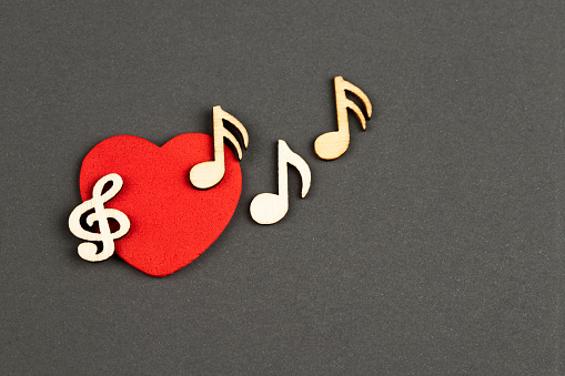Musical wooden notes with heart, top view.