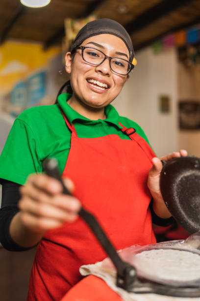 istock Cool worker preparing tortillas for mexican tacos in a restaurant 1457217358