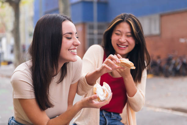 istock two friends laughing and having fun in a city park 1457227807