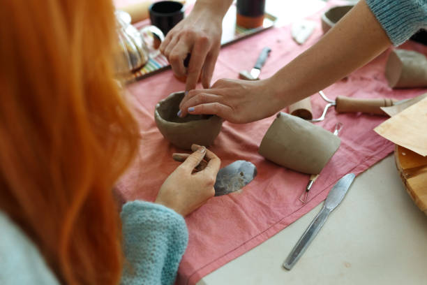istock Pottery workshop class. A pottery crafts dish from a raw clay. Creating ceramics 1457227827