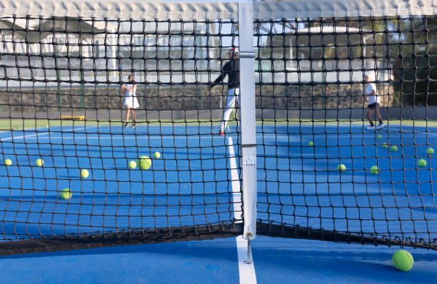 istock Tennis practice view through the net 1457228878