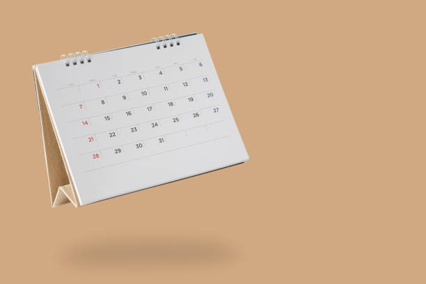 White paper desk calendar flipping page isolated on brown background White paper desk calendar flipping page isolated on brown background flip calendar stock pictures, royalty-free photos & images