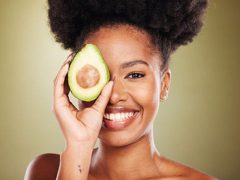 Beauty, skincare and black woman with avocado cosmetics for organic skin wellness, spa detox treatment and healthy natural vegetable diet. Portrait of happy model, glowing skin and studio background