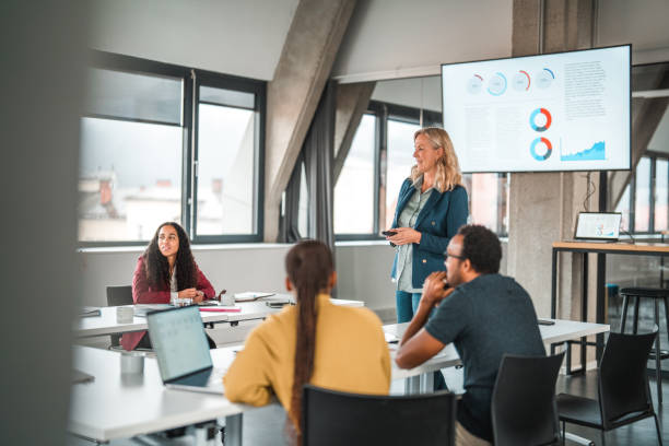 istock Blond Woman Presenting Work Results to a Mixed-Race Team 1457236747