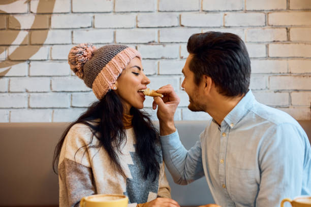 istock Happy man sharing food with his girlfriend in a cafe. 1457239236
