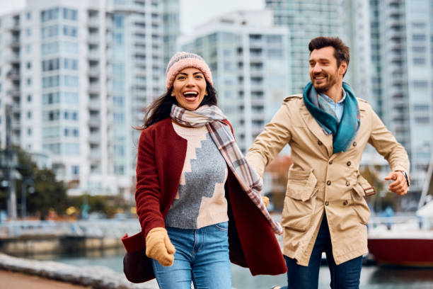 istock Cheerful couple having fun while holding hands along city quay. 1457239806