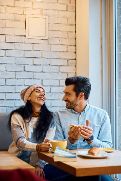 istock Happy couple having fun while talking and drinking coffee in a cafe. 1457240474