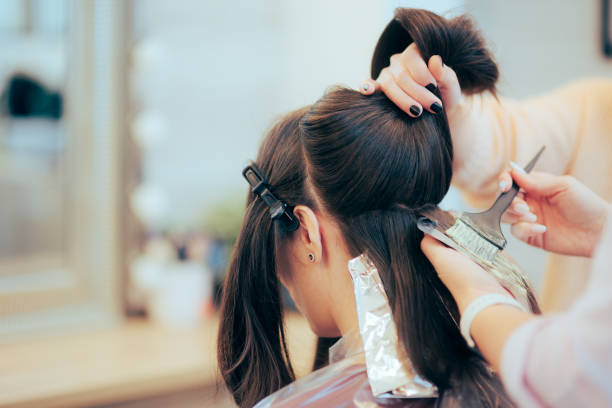 Hairdresser Sectioning and Dying the Hair of a Client Woman changing her hair style and color in a professional salon hydrogen peroxide stock pictures, royalty-free photos & images