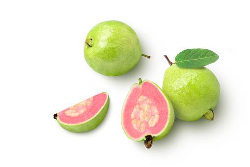 Pink guava with green leaf and slices isolated on white background, top view, flat lay.