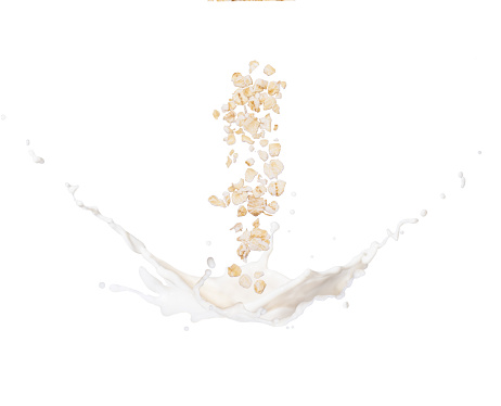 Oat flakes falling to milk splash isolated on white background.