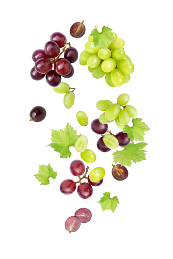 Various grapes fruit with green leaf and half sliced flying in the air isolated on white background.