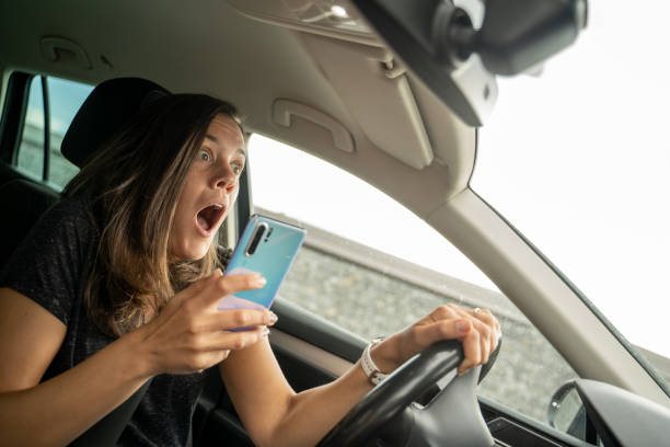 mujer jadeando cuando usa un teléfono mientras conduce - driving text messaging accident car fotografías e imágenes de stock