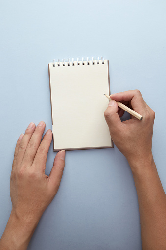 Male hands holding an open empty notebook and a pencil. Man making notes or a to-do list.