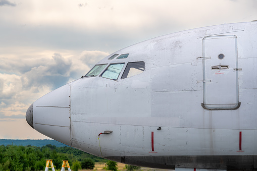 Side view, profile, close up photo of the nose and cockpit of an old passenger jet, plane, at sunset.