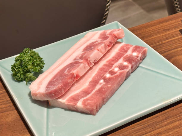 istock Grilling pork belly meat on a round BBQ net in restaurant for eating. 1457255770