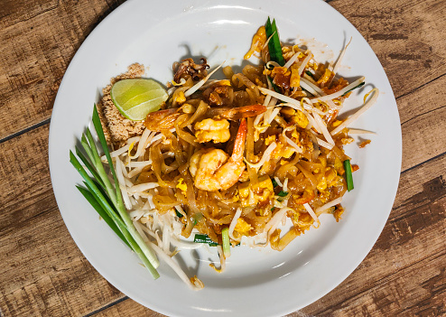 Served at a street food restaurant,ready to eat. Most popular Thai dish with western tourists.Delicious,tasty food with peanuts,shrimp,beansprout,noodles,spring onion and a slice of lime.