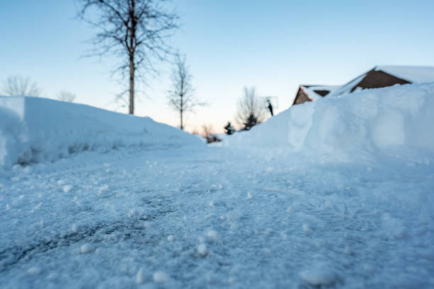 Selective focus on cut bank of a snow blown sidewalk section with path continuing. . High quality photo