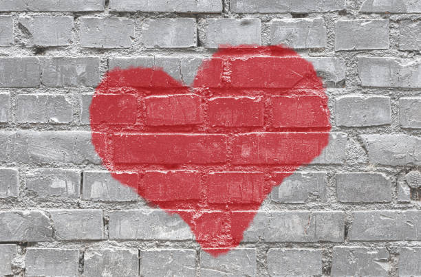 istock Gray monochrome brick wall background with red heart 1457270129