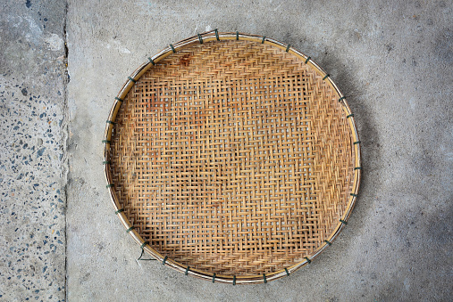 winnowing basket, bamboo threshing basket used for food airing on cement floor background