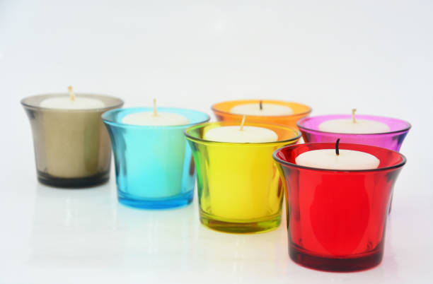 istock white candles in a colorful small glass on white background, copy space 1457272294