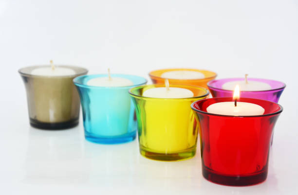 istock white candles in a colorful small glass on white background, copy space 1457272297