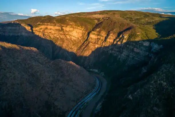 Aerial view of sunset in canyon with highway along small river.Landscape in the west.