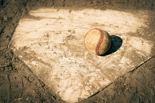 Baseball on home plate of baseball field