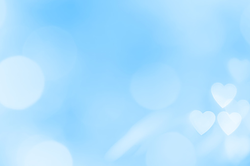 Blue defocused bokeh background with heart shape and space for your text. Can be used as a template for romantic, Valentine's day holiday greeting cards or posters.
