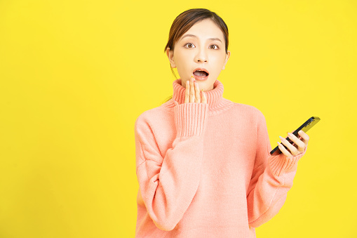 Image of young Asian girl using smartphone on background