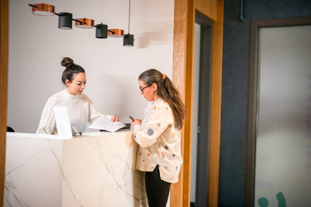istock Female patient at the front desk, filling forms 1457289101