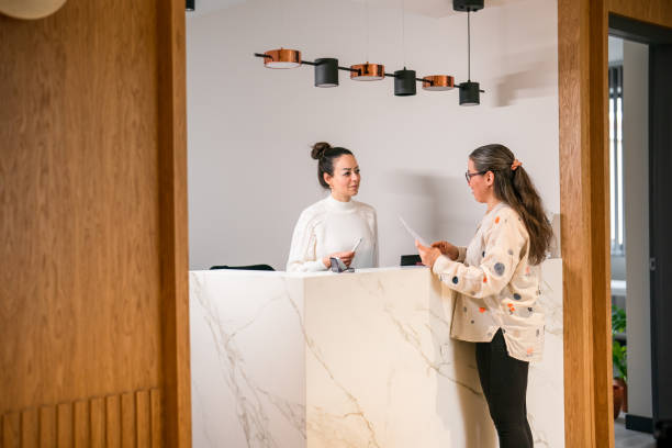 istock Female patient at the front desk, filling forms 1457289105