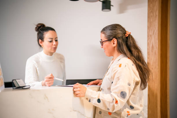 istock Female patient at the front desk, filling forms 1457289109