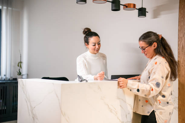 istock Female patient at the front desk, filling forms 1457289111
