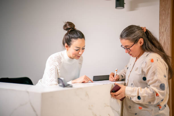istock Female patient at the front desk, filling forms 1457289129