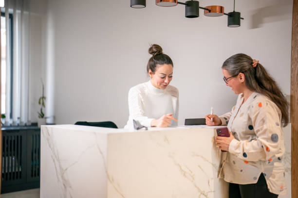 istock Female patient at the front desk, filling forms 1457289130