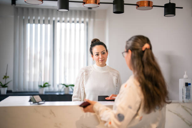 istock Female patient at the front desk, filling forms 1457289135
