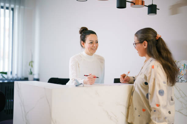 istock Female patient at the front desk, filling forms 1457289156