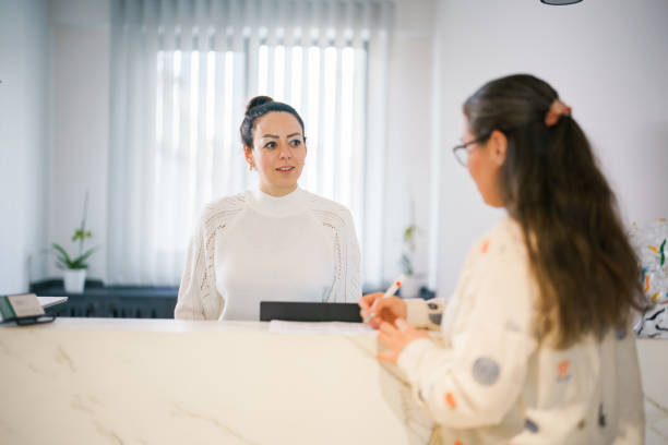 istock Female patient at the front desk, filling forms 1457289174