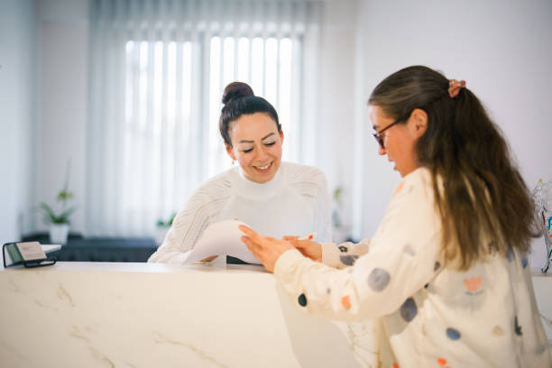 istock Female patient at the front desk, filling forms 1457289177
