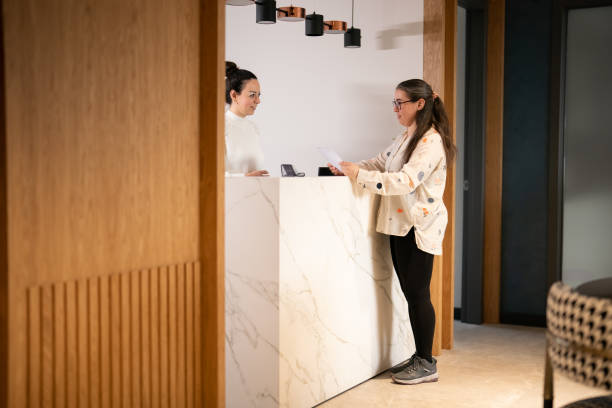 istock Female patient at the front desk, filling forms 1457289209