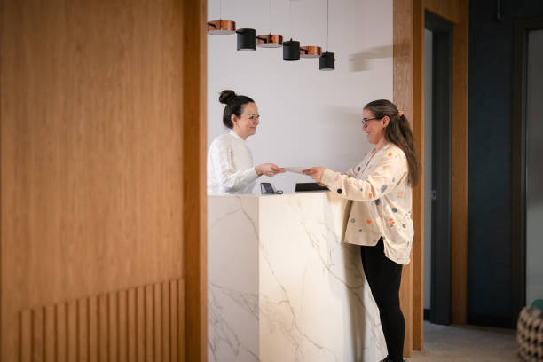 istock Female patient at the front desk, filling forms 1457289218