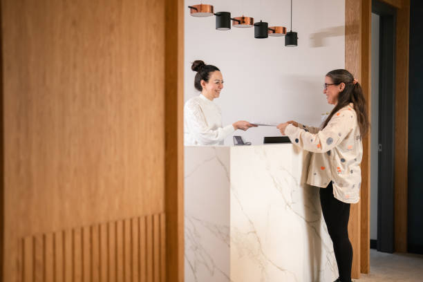 istock Female patient at the front desk, filling forms 1457289242