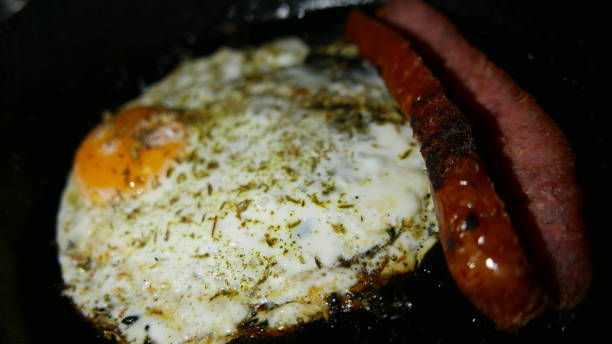 istock Hot fryer: roast sausage. Fried egg. Making dinner. Homemade meal 1457294583