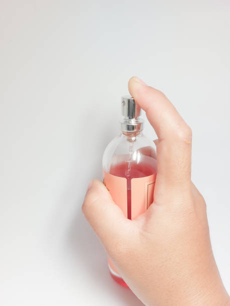 istock female hand holding a perfume bottle on a white background 1457295605