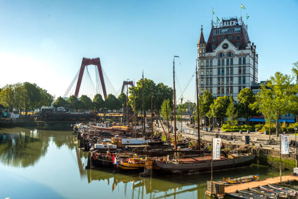 View on the old port of Rotterdam near the city centre and Rotterdam Blaak railroad station. The first pier was built in the year 1350, but today the area is well known in the nightlife scene with many pubs, cafes and restaurants. The white building in the background is called The White House, Het Witte Huis, and is the first skyscraper built in Europe