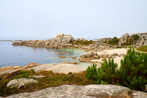 Galician beach with rocks and blue sky. Nature background.