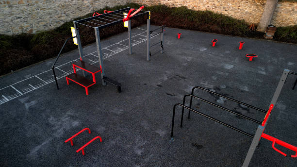 outdoor gym in the yard with stone sandstone wall and flexible rubber floor. sports ground with fitness aids, parallel bars, crossbars, rib tables made of metal . drone, top, point of view, high angle - school bench above bildbanksfoton och bilder